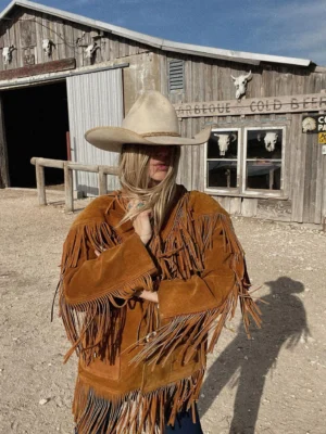 Tan 1970s fringe leather jacket with horn button closure and Western-style detailing